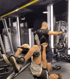 Someone pretends to lift weights at a gym